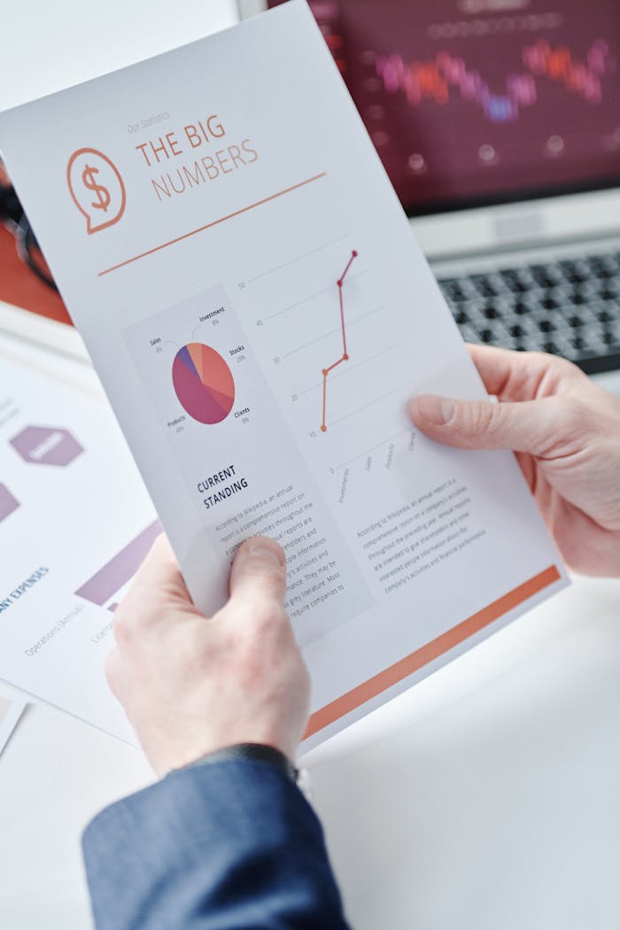 Close-up of hands holding a business report with data charts and graphs displaying financial information.